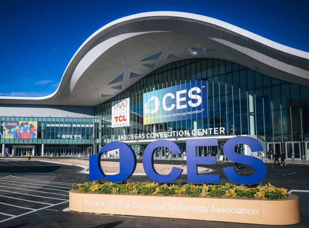 Exterior view of the Las Vegas Convention Center with a large blue OCES sculpture and a planter in the foreground.