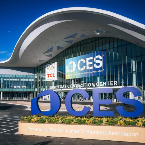 Exterior view of the Las Vegas Convention Center with a large blue OCES sculpture and a planter in the foreground.